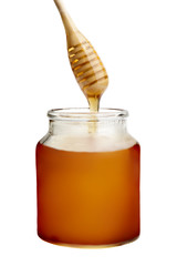 Honey dripping in jar from a drizzler isolated on white