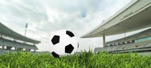 Classic soccer ball on green grass in a big stadium