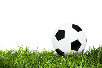 Classic soccer ball on green grass isolated on white