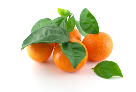 Ripe fresh mandarines with green leaves over white