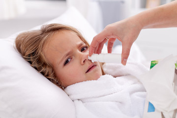 Obraz na płótnie Canvas Dziewczynka z przeziębienie używając aerozolu do nosa