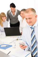 Businessman use phone during team meeting