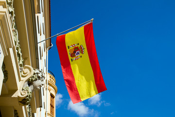 Naklejka premium Spanish flag waving at an old building