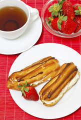 fresh cream puff with whipped cream and strawberry and cup of te