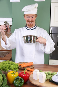 Funny young chef strange looking at pot