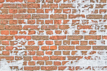 Old snowy wall made from red brick