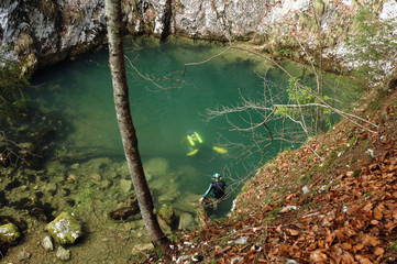 Naklejka premium A cave diver emerges from a spring