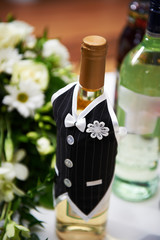 Bottle of vine in the costumes of groom