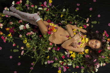 Beautiful young nude woman with flowers