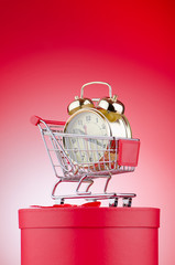 Buying time concept with clock and shopping cart
