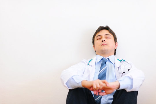 Tired Medical Doctor Sitting On Floor And Relaxing