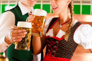 Paar in Tracht mit Bier Glas in Brauerei