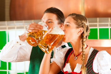 Paar in Tracht mit Bier Glas in Brauerei