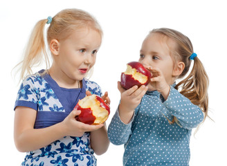 Two little pretty girls eating apples