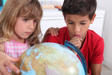 Boy and girl sat with globe