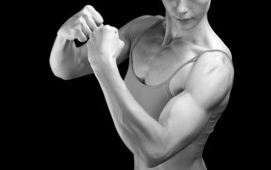 Fototapeta na wymiar Female fitness bodybuilder posing against black background
