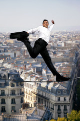 Businessman confidently walking across tight rope