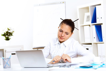 Young beautiful woman in business wear at work