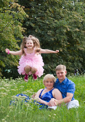 Happy family on the nature on a green grass