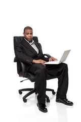 African American businessman sitting in chair with laptop