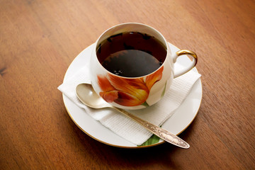 porcelain teacup and saucer on a wooden table