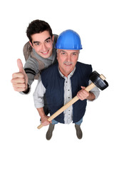 Experienced tradesman posing with his new apprentice