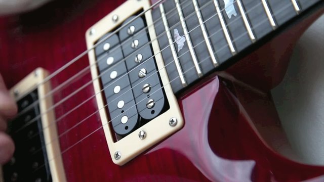 Gitarre spielen mit Saiten und Plektron