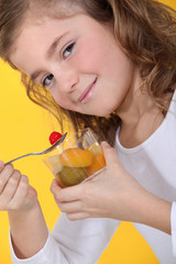 Little girl eating fruit salad