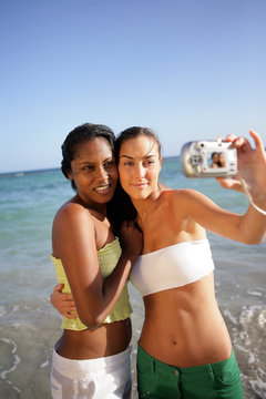 Two female friends taking self-portrait at the beach