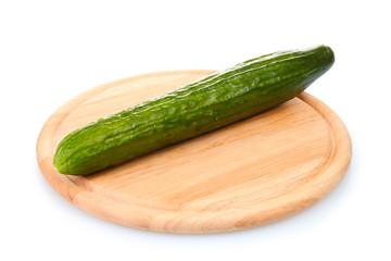 long cucumber on wooden cutting board isolated on white