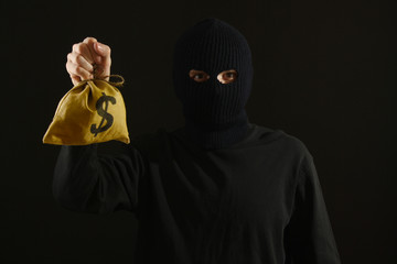 Bandit in black mask with money isolated on black