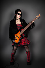 Fashion style photo of young rocked woman in studio  with guita