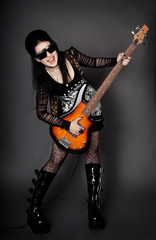 Fashion style photo of young rocked woman in studio  with guita