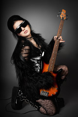 Fototapeta premium Fashion style photo of young rocked woman in studio with guita