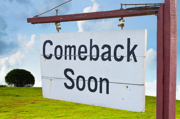Come back soon wood sign with hill and sky