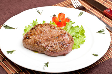 Grilled steak on a white plate