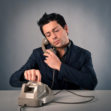 Man talking at the phone against dark background.