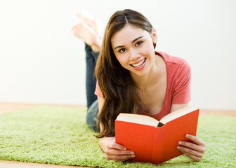 Young woman reading the book at home