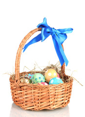 Colorful Easter eggs in the basket with a blue bow isolated