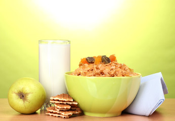 tasty cornflakes in green bowl, apple and glass of milk