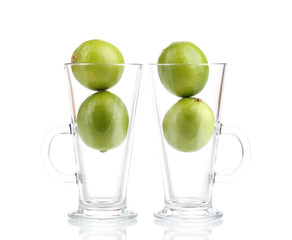 Fresh limes in glass cups isolated on white
