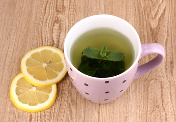 Mint tea with mint leaf and lemon on wooden background