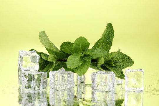 Fresh Mint Leaf And Ice Cubes With Droplets On Green Background