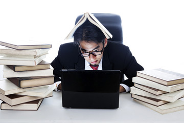 Stressed businessman in working with books