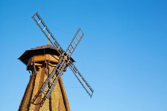 Old wooden mill against the blue sky