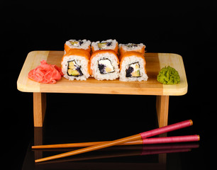 Tasty rolls served on wooden plate isolated on black