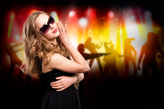 junge blonde Frau mit Sonnenbrille vor Party-Hintergrund