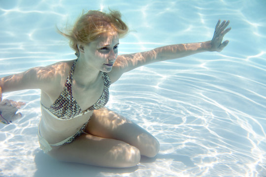 Girl swimming underwater in a swimming pool