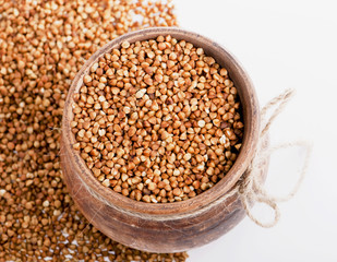 raw buckwheat in bowl isolated on white