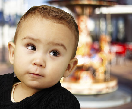 portrait of adorable baby looking up against a carousel